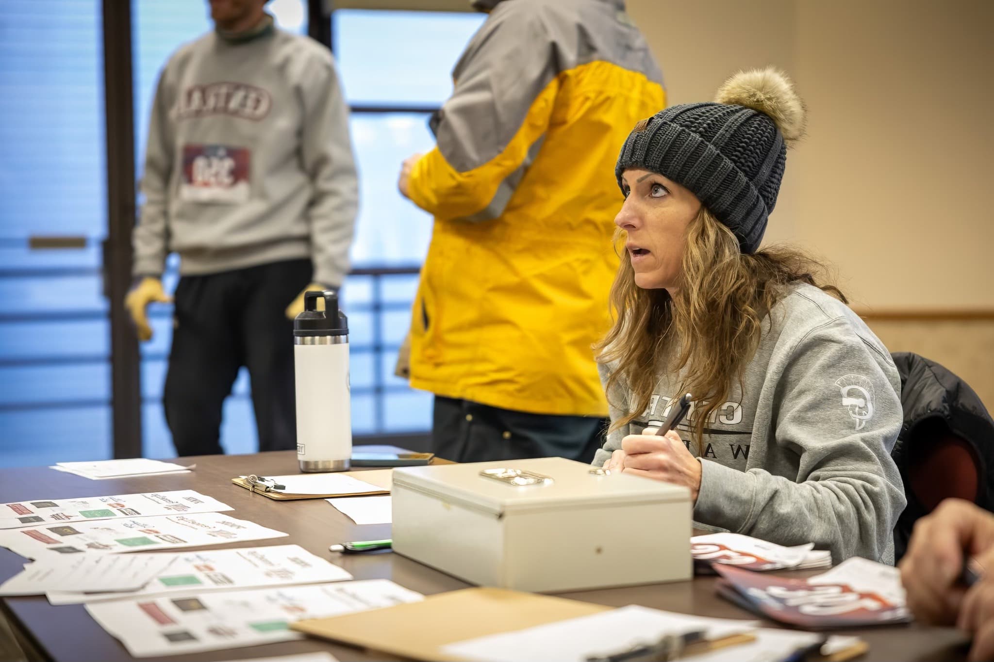 A volunteer at the check-in table handing out bibs